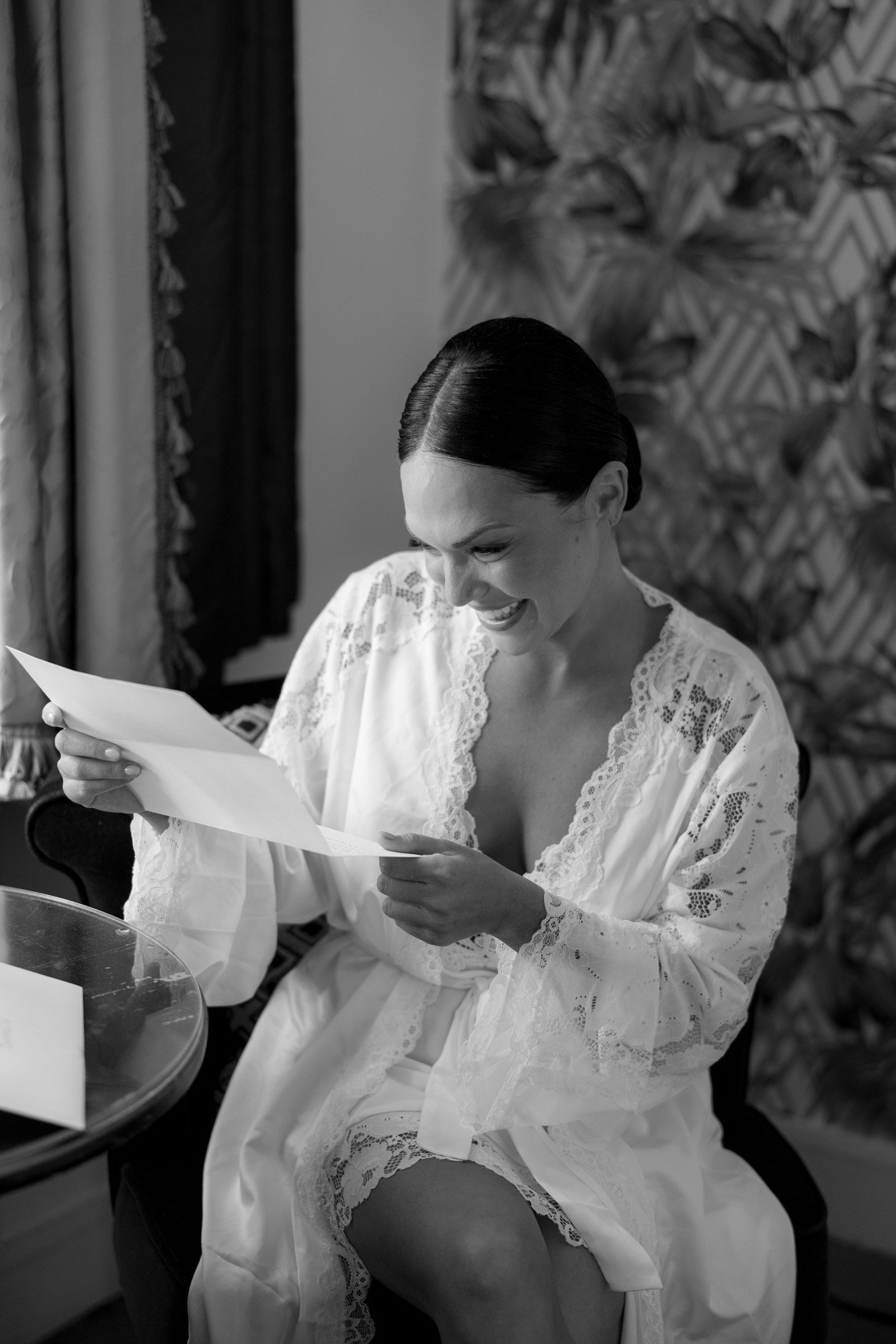 A woman in a white robe reading a letter.