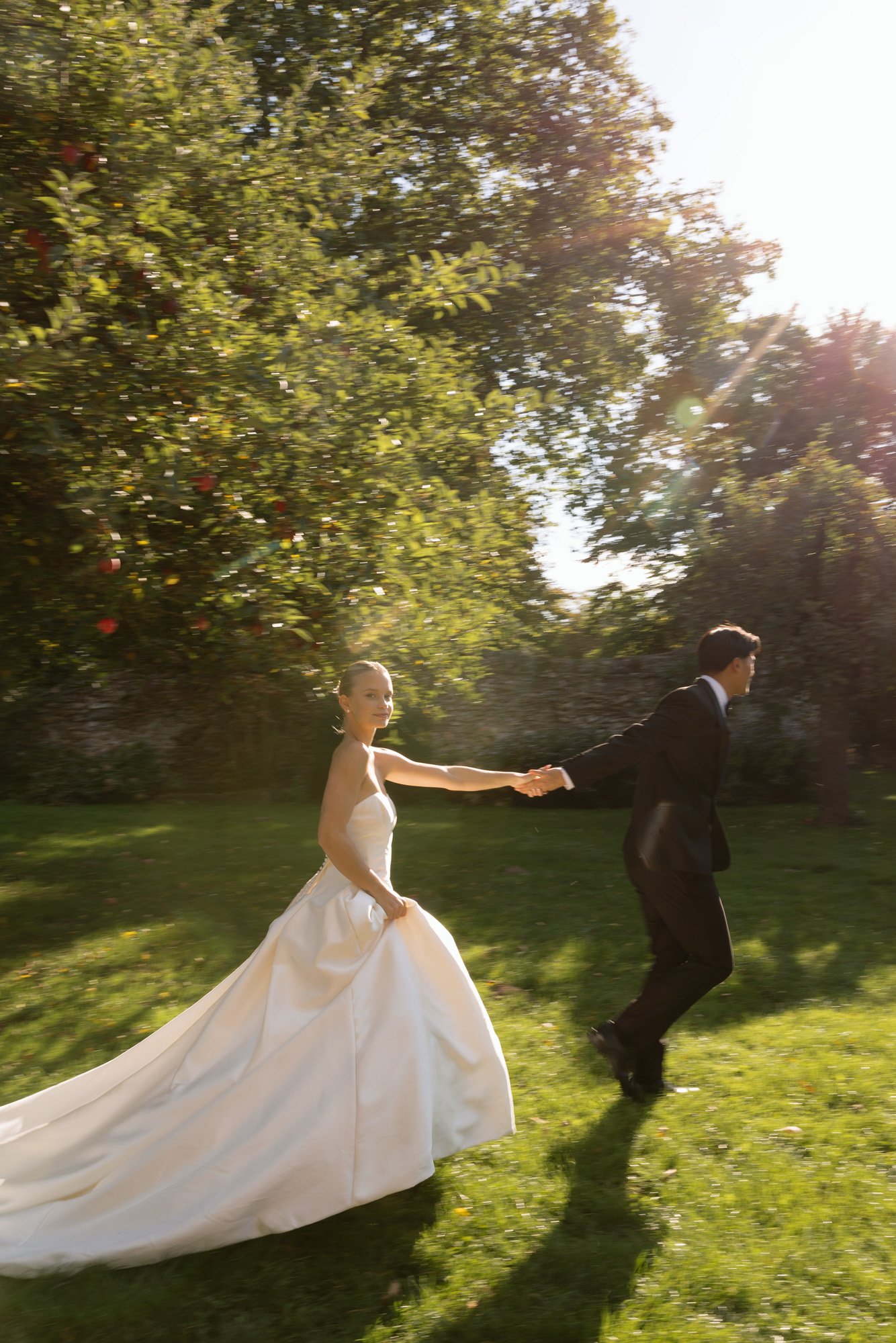 A man and woman in a wedding dress holding hands. Manoir de Vacheresses wedding.