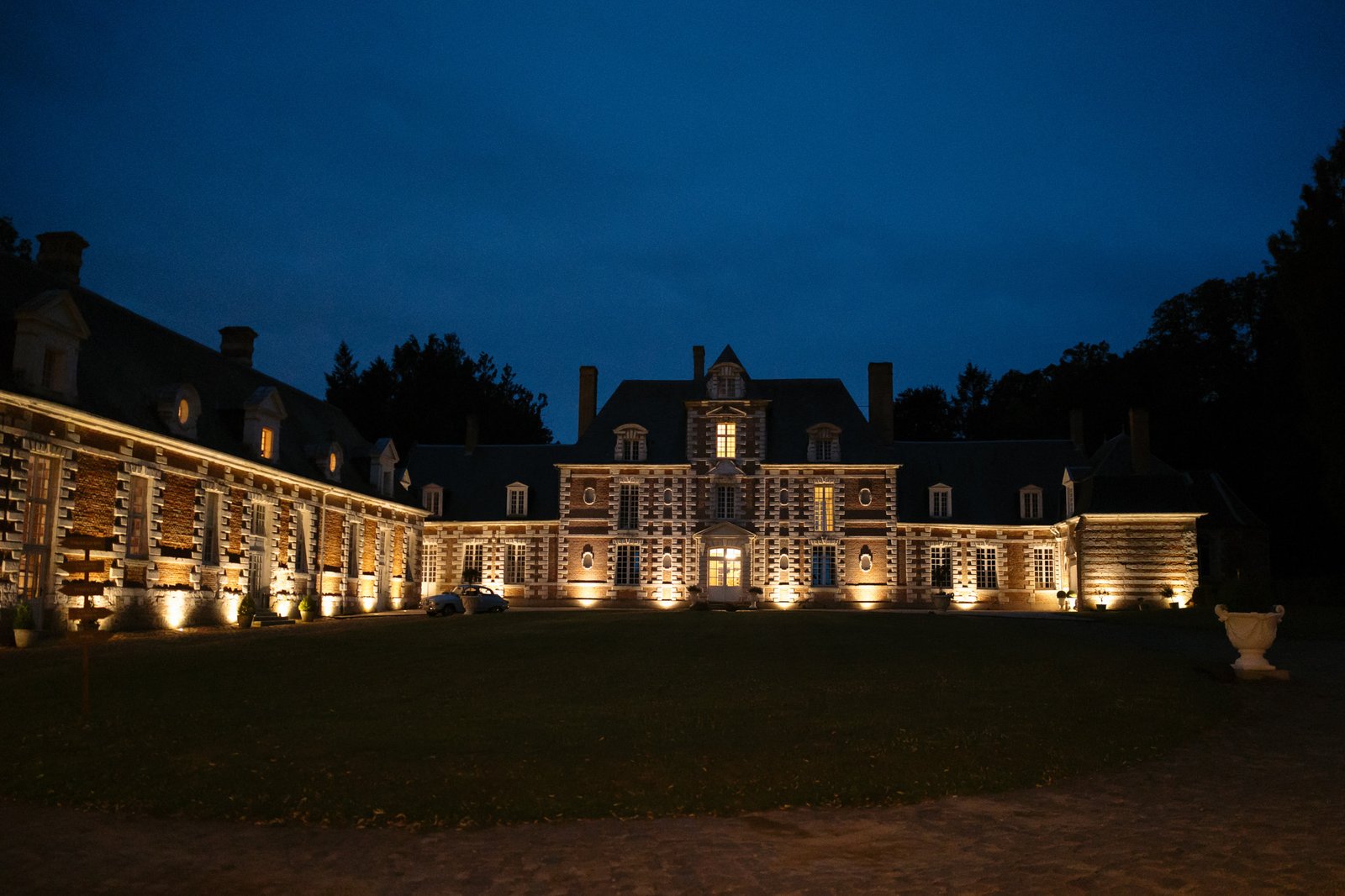A large brick building with lights on the outside. Captured by Northern France wedding photographer.