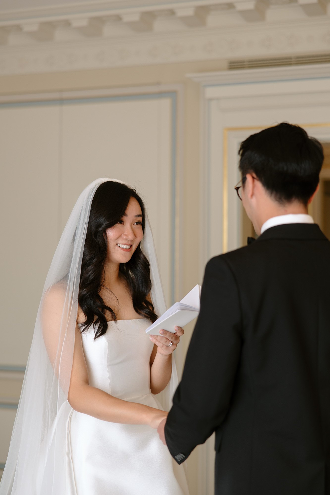 A woman in a white dress holding a white card.
