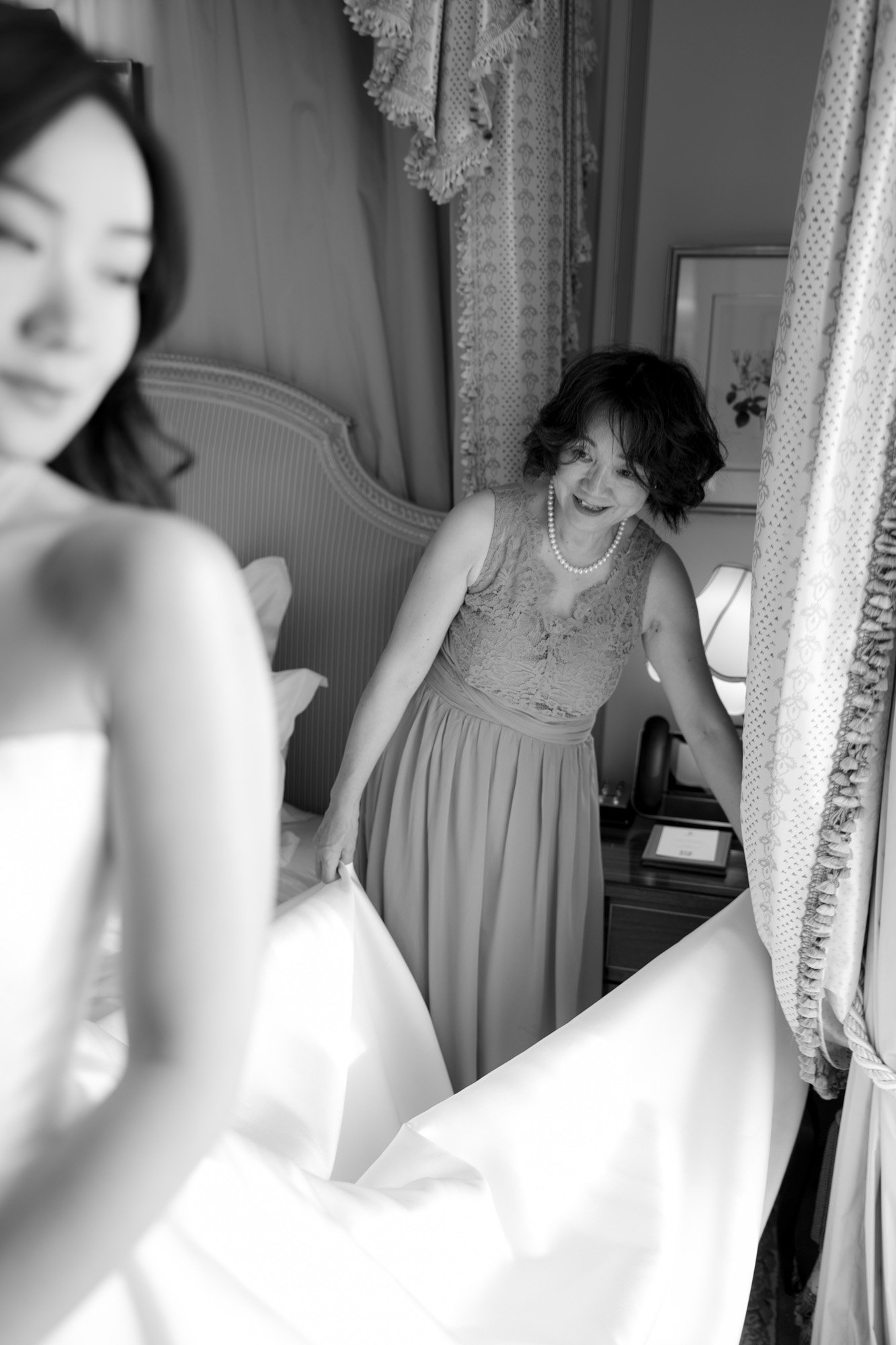 A woman in a dress looking at a mirror.